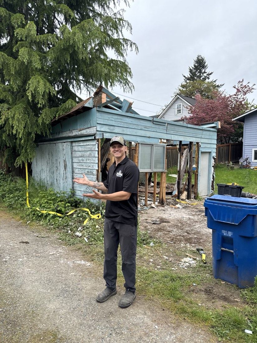 Jake's Junk Removal crew member mid-demolition of an old backyard shed